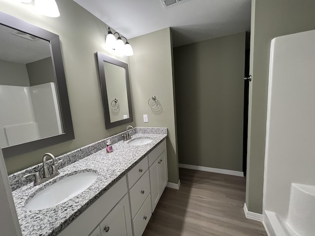 bathroom featuring a shower, hardwood / wood-style floors, and vanity