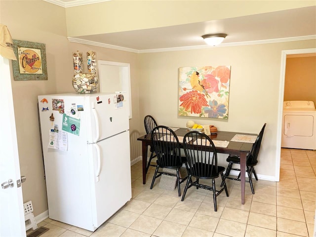 tiled dining space with washer / dryer and crown molding