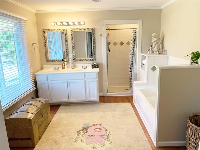 bathroom with vanity, wood-type flooring, ornamental molding, and shower with separate bathtub