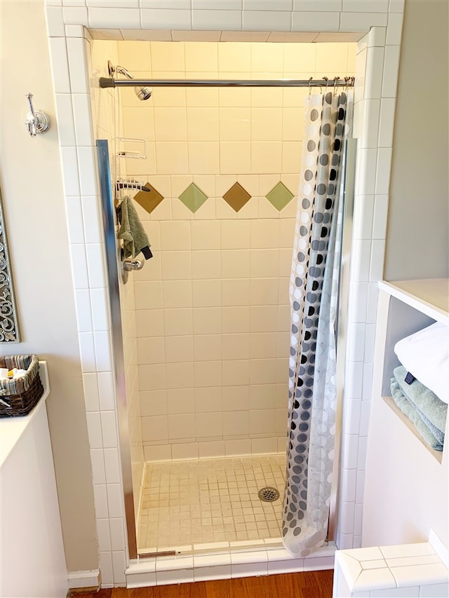 bathroom featuring a shower with shower curtain and hardwood / wood-style flooring