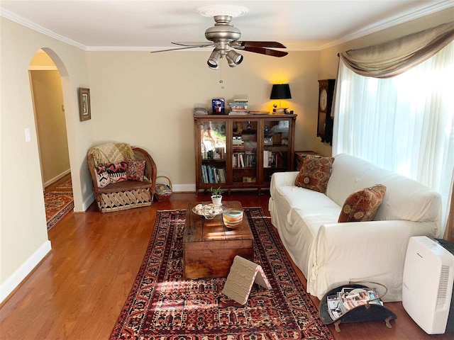 living room featuring ceiling fan, wood-type flooring, and ornamental molding