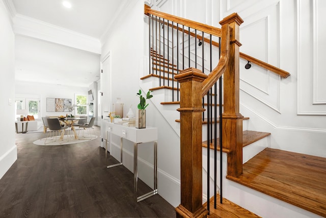 stairway with hardwood / wood-style floors and ornamental molding