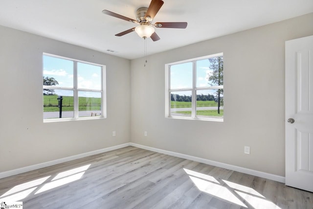 unfurnished room with plenty of natural light, ceiling fan, and light hardwood / wood-style flooring