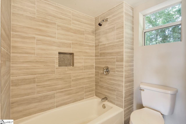 bathroom featuring toilet and tiled shower / bath