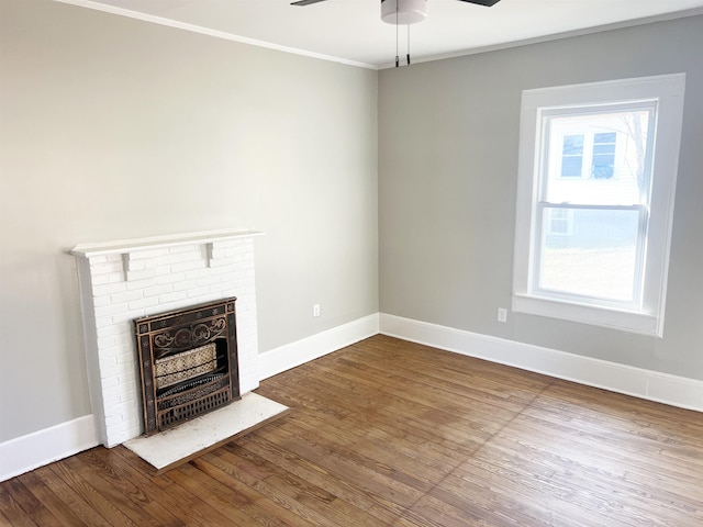 unfurnished living room featuring hardwood / wood-style floors, a brick fireplace, plenty of natural light, and crown molding