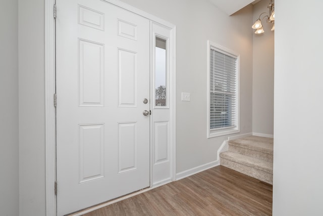 foyer with a notable chandelier and light hardwood / wood-style floors