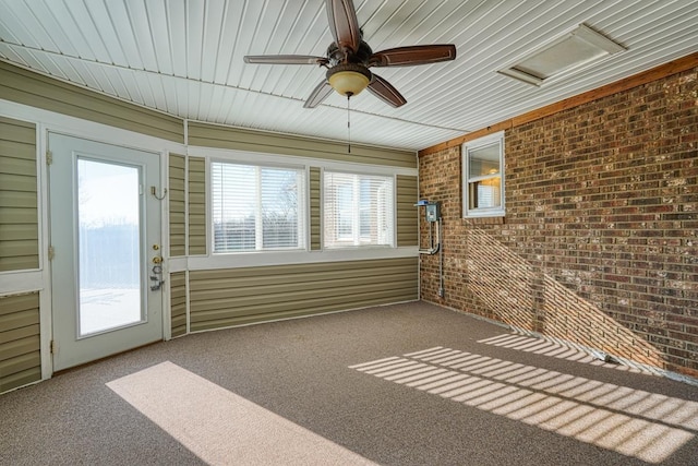 unfurnished sunroom featuring ceiling fan