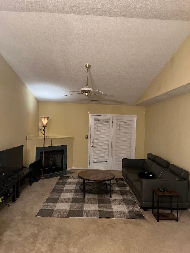 living room with vaulted ceiling, ceiling fan, carpet floors, and a textured ceiling