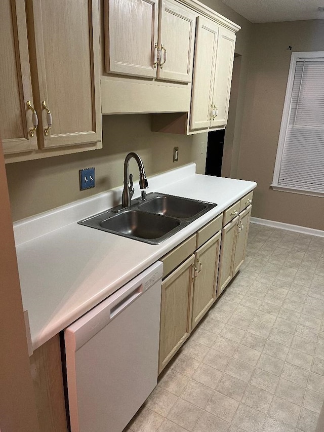 kitchen featuring light brown cabinetry, sink, and white dishwasher