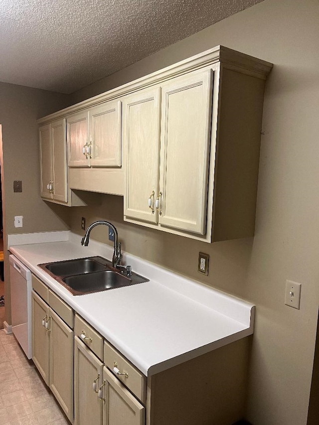 kitchen featuring sink, white dishwasher, and a textured ceiling