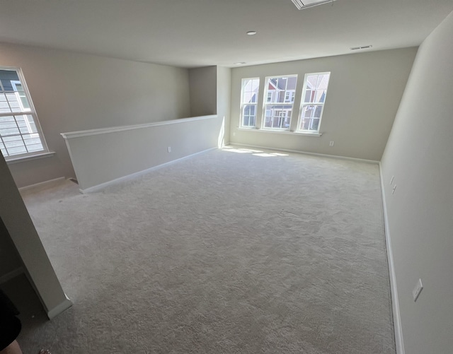 spare room featuring carpet flooring and a wealth of natural light