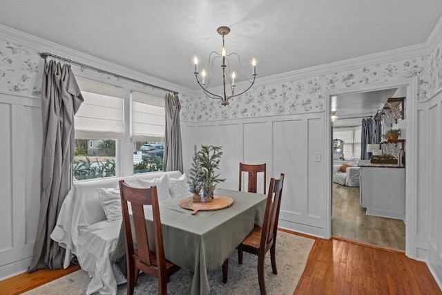 dining room with a chandelier, hardwood / wood-style floors, and crown molding