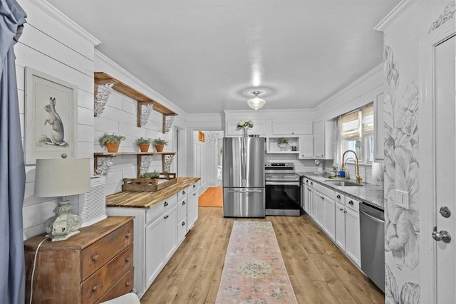 kitchen featuring white cabinetry, sink, stainless steel appliances, and light hardwood / wood-style floors