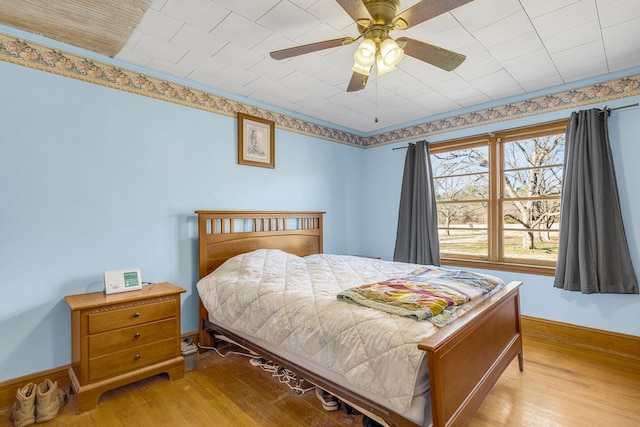 bedroom featuring light hardwood / wood-style floors, ceiling fan, and crown molding