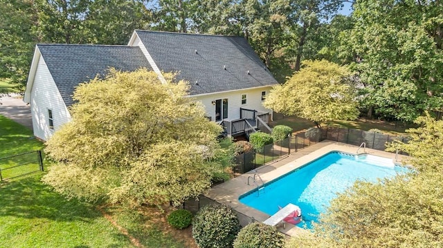 view of swimming pool featuring a yard and a diving board