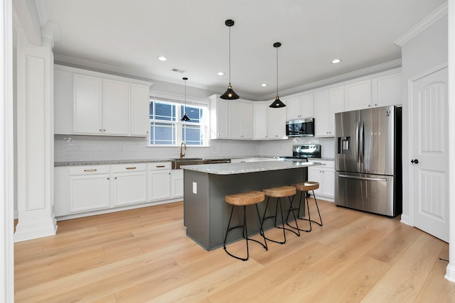 kitchen with stainless steel appliances, white cabinetry, a center island, tasteful backsplash, and hanging light fixtures