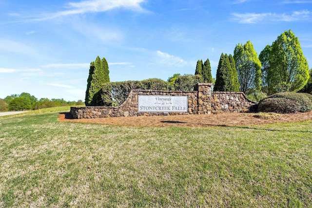 community / neighborhood sign featuring a yard