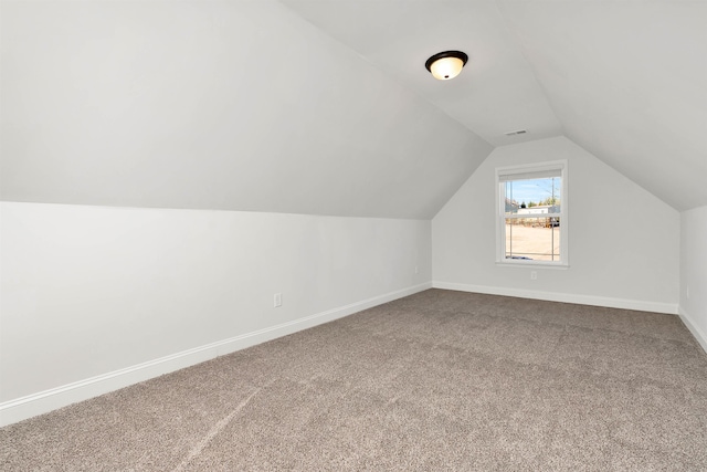 bonus room with carpet flooring and vaulted ceiling