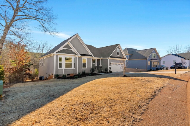 view of front facade featuring a garage, a front lawn, and central AC unit