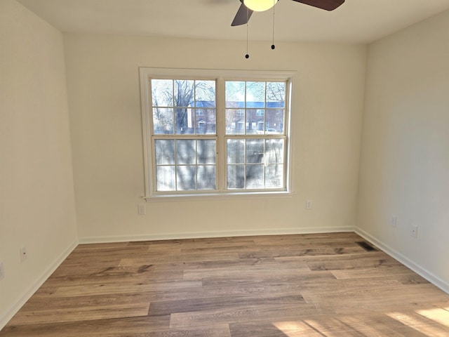 spare room with ceiling fan and light wood-type flooring