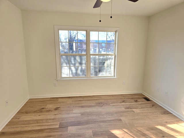 spare room with light wood-type flooring and ceiling fan