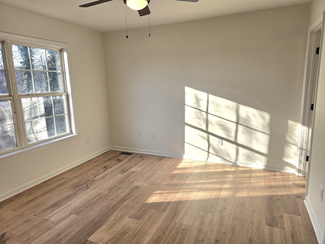 spare room with light wood-type flooring and ceiling fan