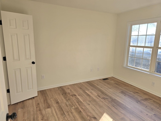 spare room with light hardwood / wood-style flooring