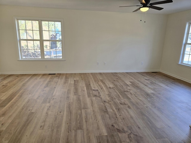 empty room with ceiling fan and light hardwood / wood-style flooring