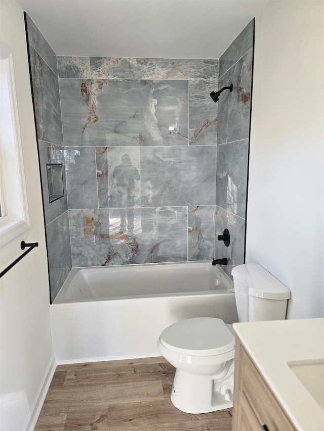 full bathroom with hardwood / wood-style floors, toilet, vanity, and tiled shower / bath combo