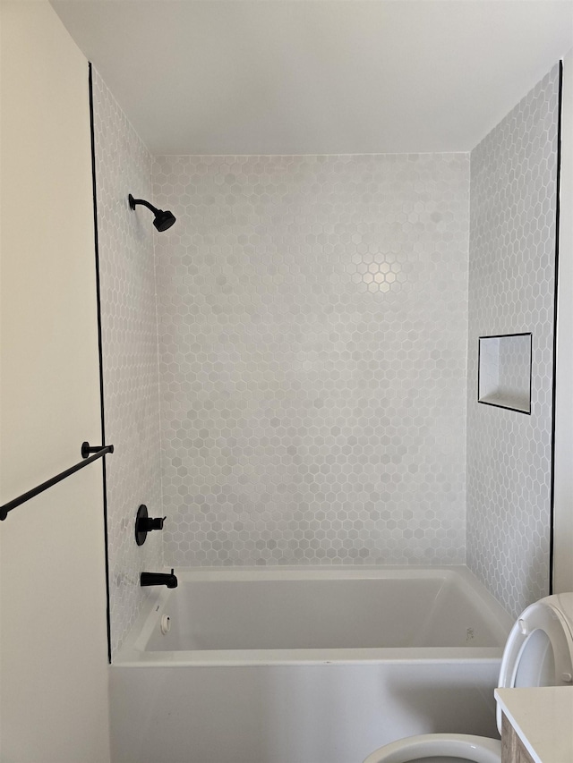 full bathroom with tiled shower / bath combo, vanity, and toilet