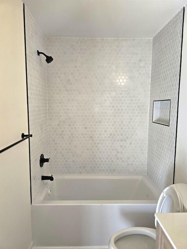 full bathroom with vanity, tiled shower / bath, and toilet