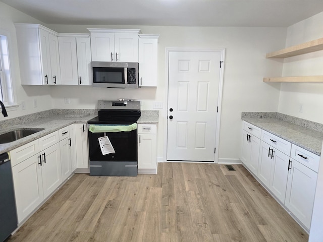 kitchen featuring sink, appliances with stainless steel finishes, white cabinetry, and light stone countertops