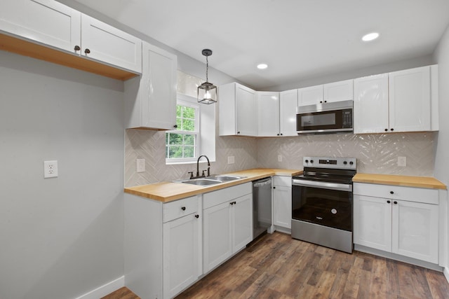 kitchen with sink, decorative light fixtures, white cabinets, and appliances with stainless steel finishes