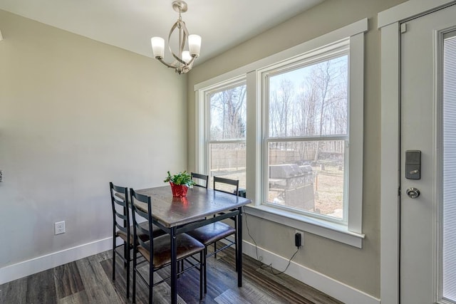 dining room featuring dark wood-type flooring, an inviting chandelier, and a healthy amount of sunlight