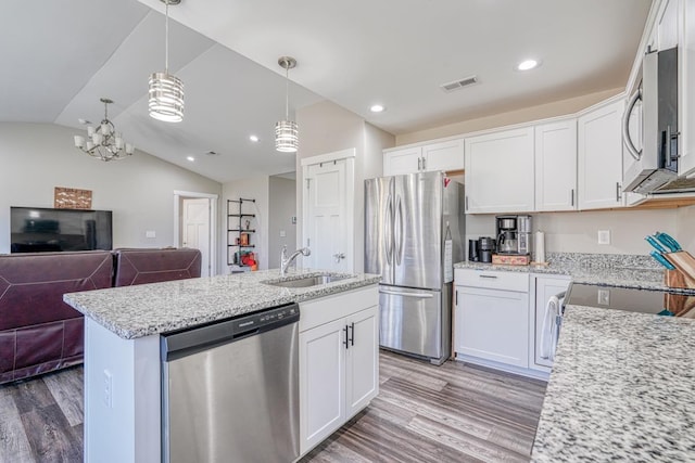 kitchen featuring white cabinets, appliances with stainless steel finishes, hanging light fixtures, and sink