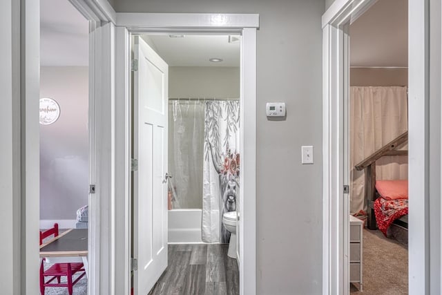 bathroom with toilet, shower / bath combo, and hardwood / wood-style floors