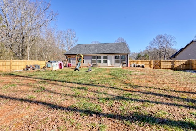 rear view of house with a storage unit and a lawn