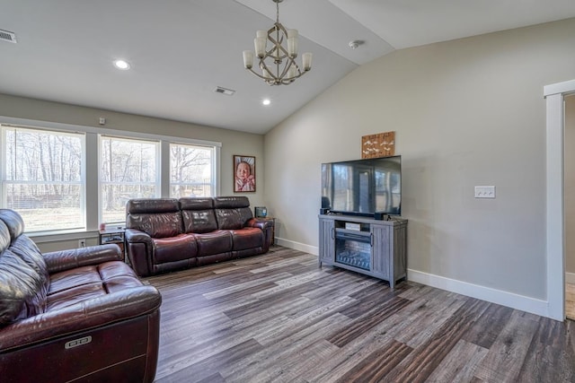 living room with wood-type flooring, vaulted ceiling, and a chandelier