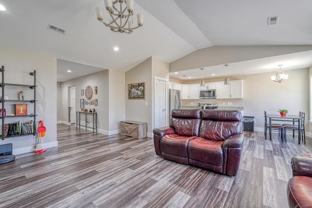 living room with light hardwood / wood-style floors, lofted ceiling, and a chandelier