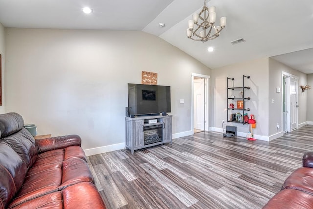 living room with a notable chandelier, hardwood / wood-style floors, and lofted ceiling