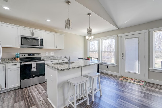 kitchen with stainless steel appliances, a center island with sink, white cabinetry, and sink