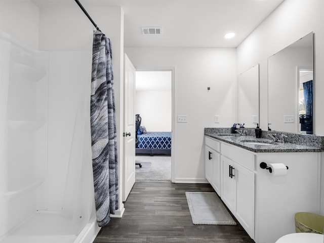 bathroom with a shower with shower curtain, vanity, and hardwood / wood-style floors