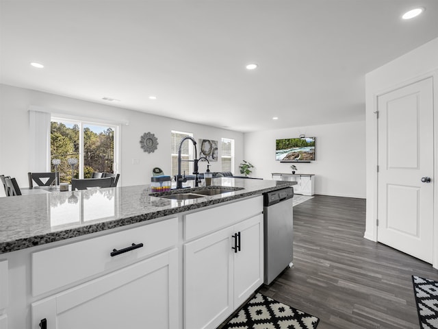 kitchen with sink, white cabinetry, dishwasher, dark stone counters, and dark hardwood / wood-style flooring