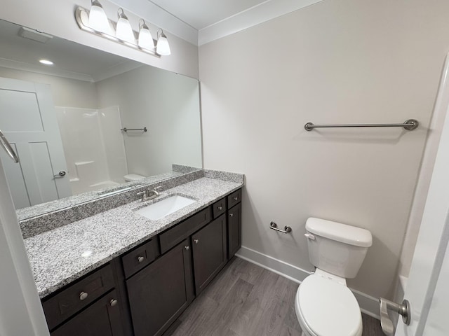 bathroom with toilet, hardwood / wood-style flooring, ornamental molding, and vanity