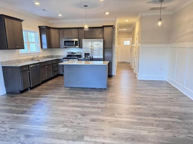 kitchen featuring a kitchen island, sink, appliances with stainless steel finishes, and hanging light fixtures