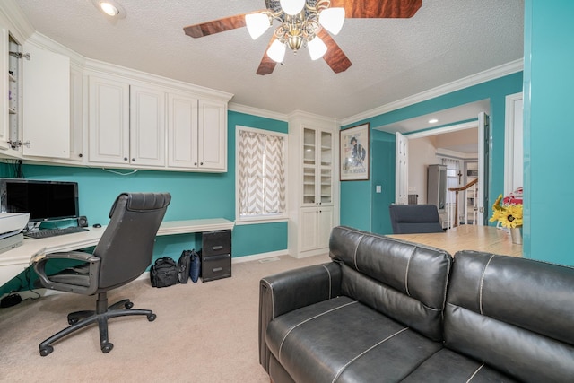 office with ceiling fan, light colored carpet, crown molding, and a textured ceiling