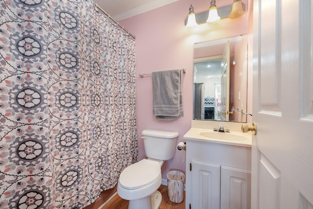 bathroom with a textured ceiling, ornamental molding, hardwood / wood-style floors, toilet, and vanity