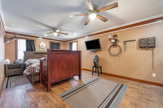 bedroom with wood-type flooring, a textured ceiling, ceiling fan, and crown molding