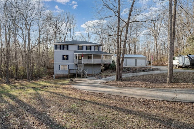 view of front of home with a garage, covered porch, and an outdoor structure