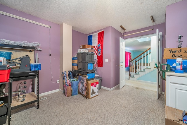 playroom with light colored carpet and a textured ceiling